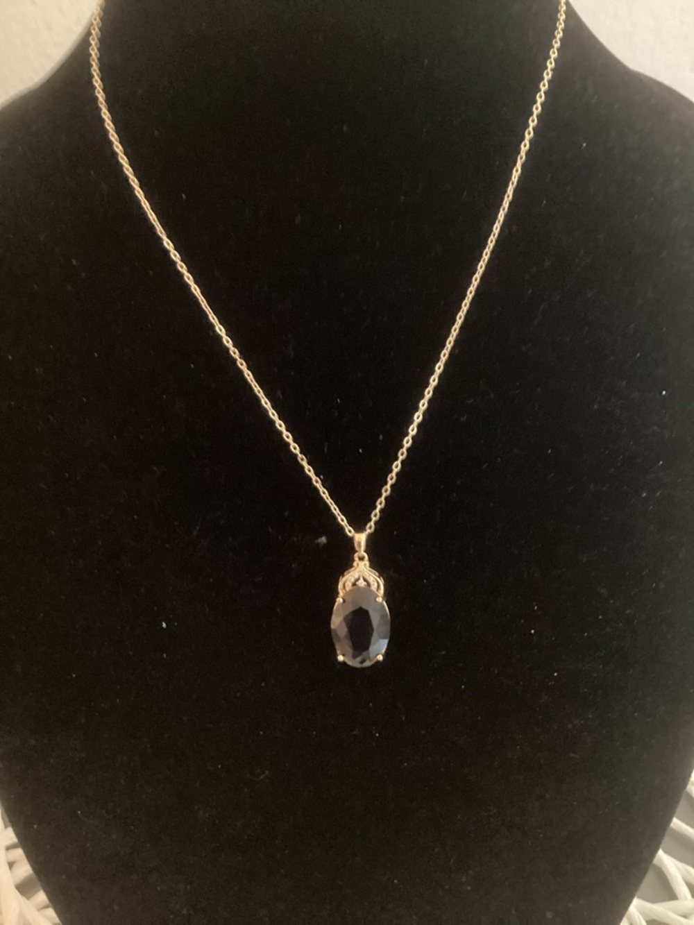 Gold Pendant Necklace with a Purple Colored Gem.